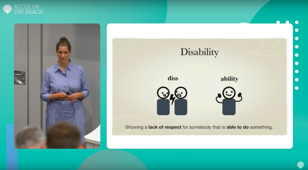A screenshot from the talk. On the left side is a middle aged woman (Madita) in a blue/white striped dress critically looking up to the audience.
On the right is a slide with the title "Disability". Below are two drawn figues with a flash between them on the left. The word "diss" is written above them.
On the right side of the slide is and a sigle drawn figure pulling up the arms showing power and the word "ablity" written above.
Below the drawings is the text "Showing a [bold]lack of respect[bold_end] for somebody that is [bold]able to do[bold_end] something."