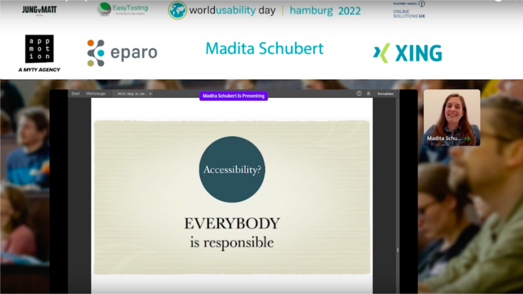 On a screen framed by the logos of several companies (see below) a presentation slide is shown: In a green filled circle the words Accessibility?
Below it: EVERYBODY is responsible
On the right is a small window with the camera-view of middle aged woman smiling at the camera while speaking. She has long brown hair and is wearing a jeans shirt. On the screen is a purpel banner saying: "Madita Schubert is Presenting" 

The companies on top of the screen are: First row on top: JungvMatt, Easy Testing, world usability day | Hamburg 2022, Kühne + Nagel, Online solutions UX.
Second row: app-mot-ion a MYTY agency, eparo, Madita Schubert, Xing